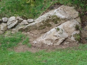 Ein Findling im Steingarten sollte so in das Erdreich eingelassen werden, dass dieser natürlich wirkt.